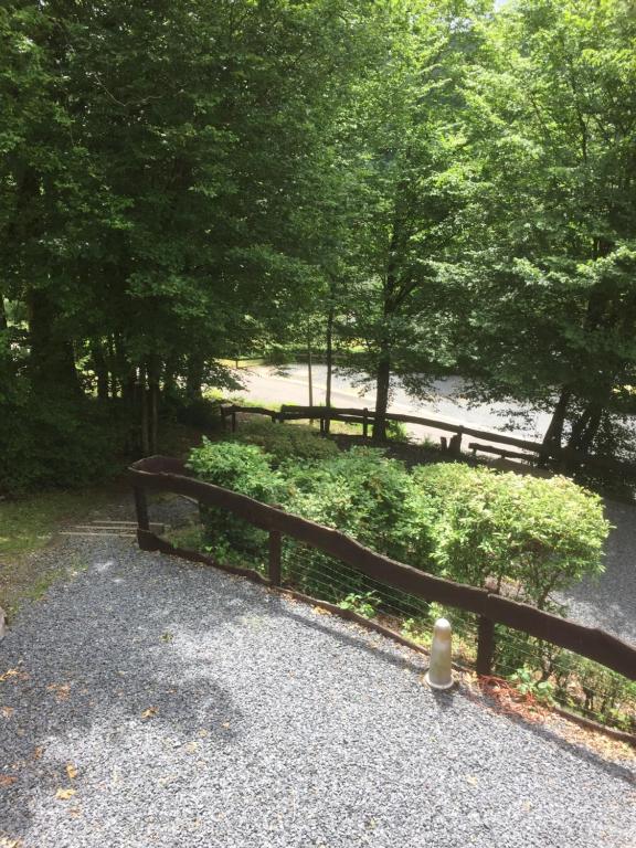 une clôture en bois dans un parc planté d'arbres et de buissons dans l'établissement Relax Semois, à Vresse-sur-Semois
