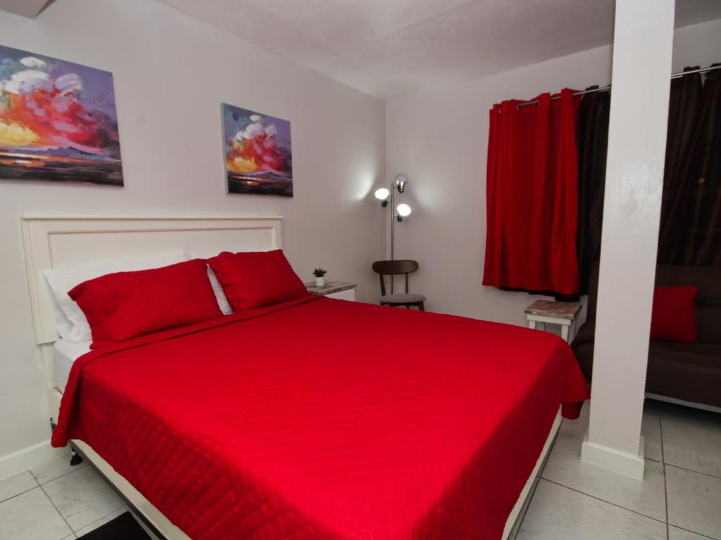 a red bed with red pillows in a bedroom at The Castle in Philipsburg