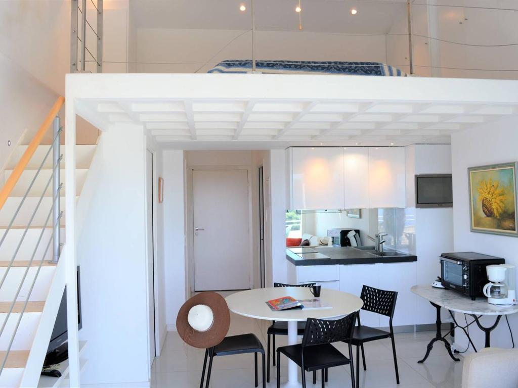 kuchnia i jadalnia ze stołem i krzesłami w obiekcie Duplex moderne 5 pers avec terrasse et parking - FR-1-251-456 w mieście Le Lavandou