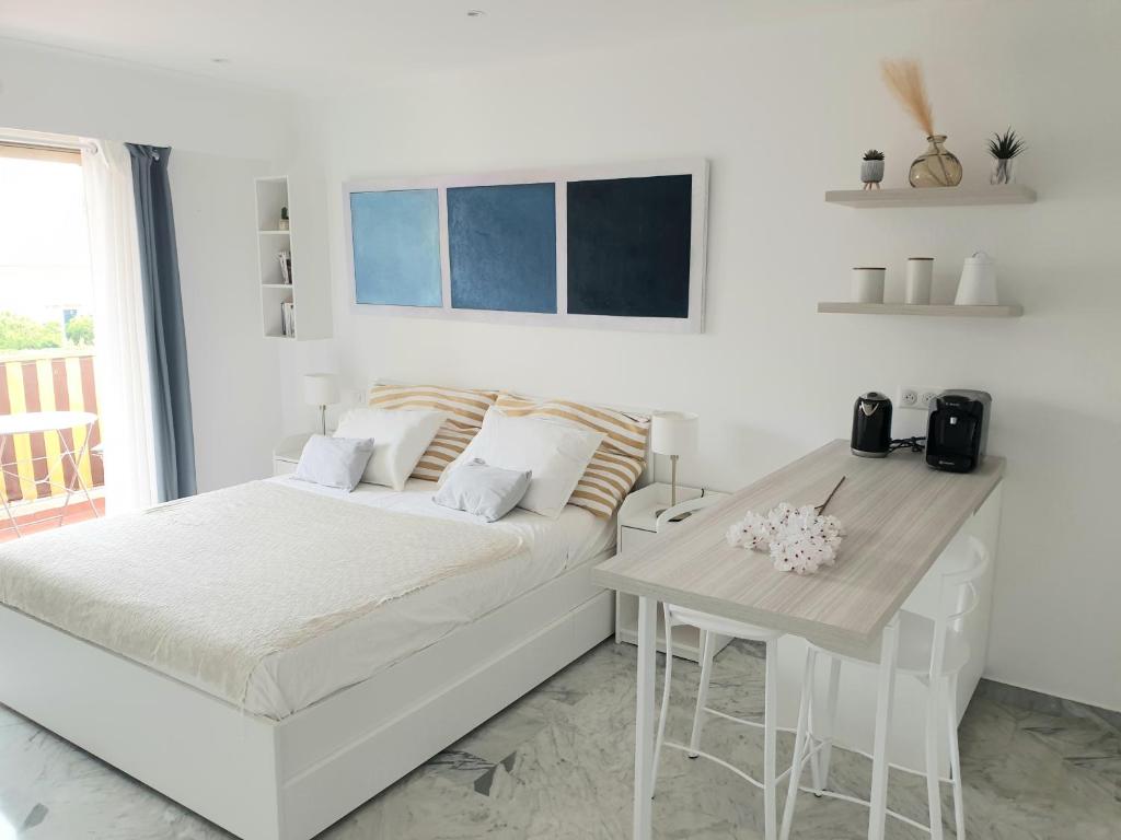 a white bedroom with a bed and a table at Beautiful T1 with sea view in Nice