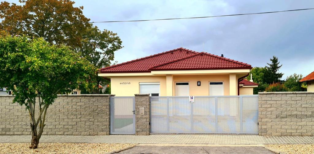 una casa con una valla y un garaje en Rekreačný dom Flóra ll, en Veľký Meder