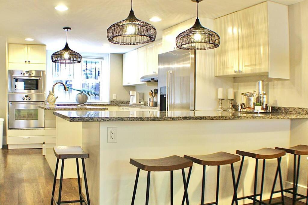 cocina con barra con taburetes en Luxury - Pet Friendly 3bd, 3ba South End Condo en Boston
