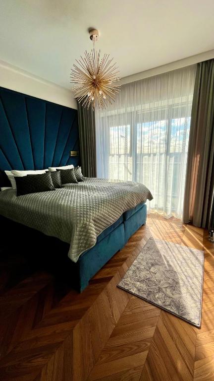 a bedroom with a large bed with a blue headboard at Hanza 1107 in Szczecin