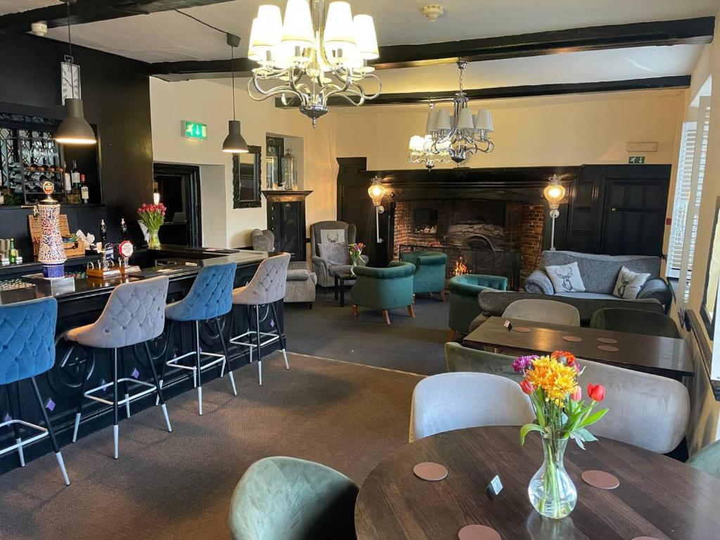 a restaurant with tables and chairs and a bar at Scole Inn Hotel in Diss