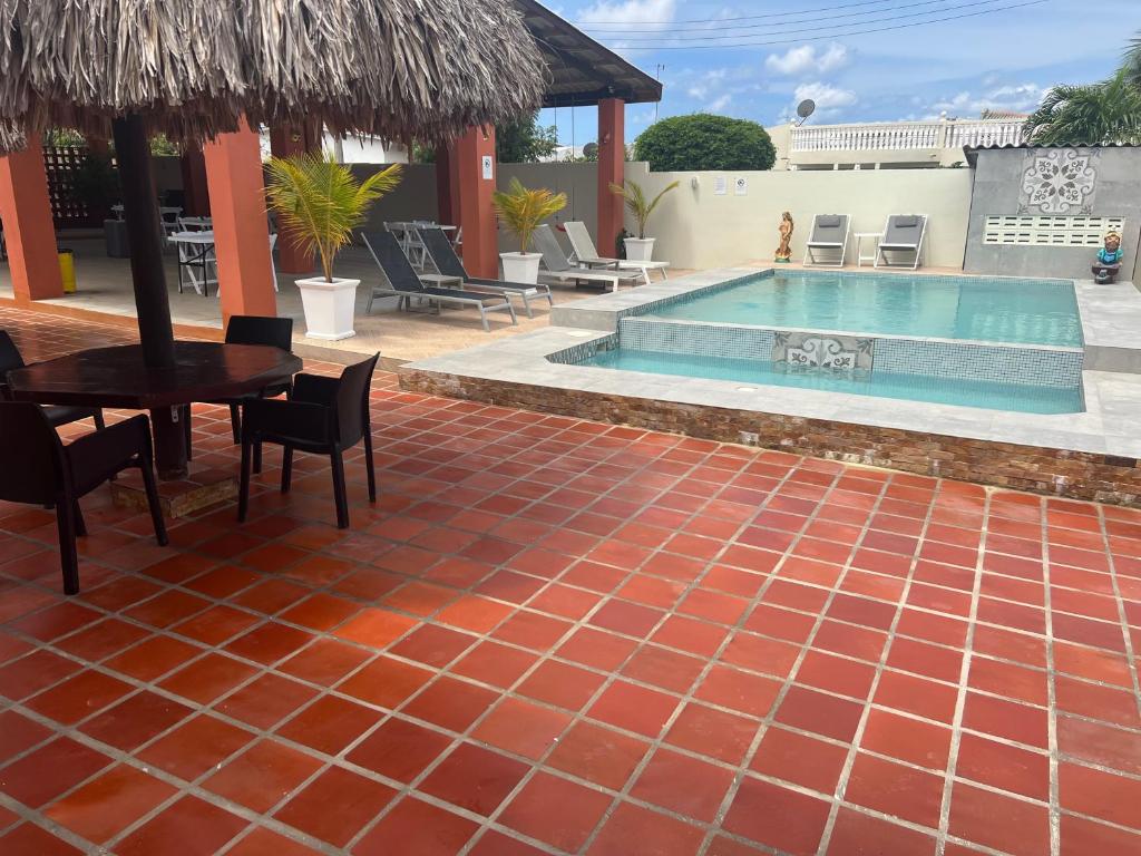 a patio with a pool and a table and chairs at Curasita colour Appartments in Willemstad