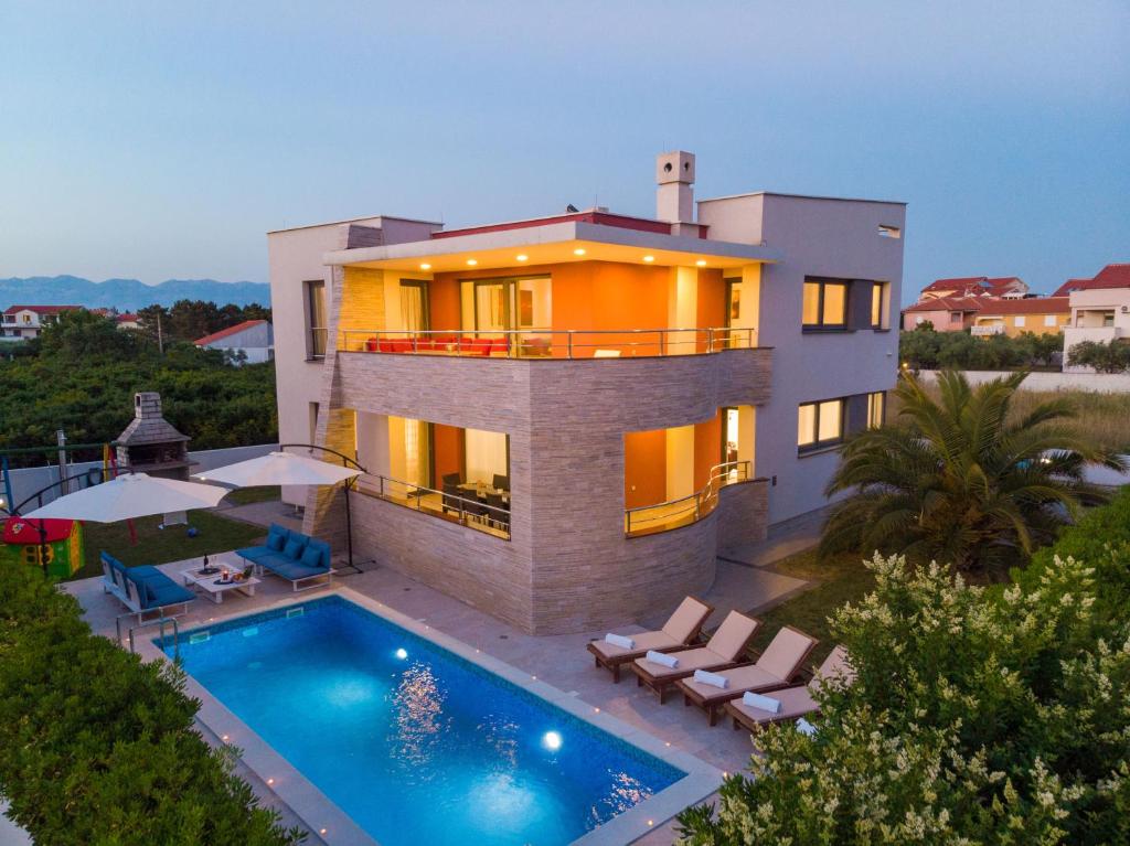 a house with a swimming pool in front of it at Vila Zatona Sunset with heated swimming pool in Zaton