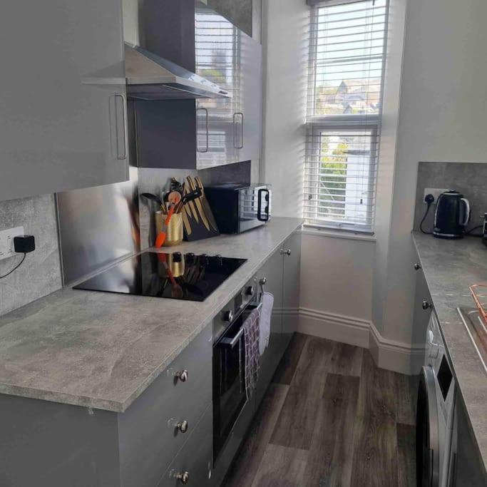 a kitchen with a stove and a counter top at First floor apartment in Stratton, Bude in Stratton
