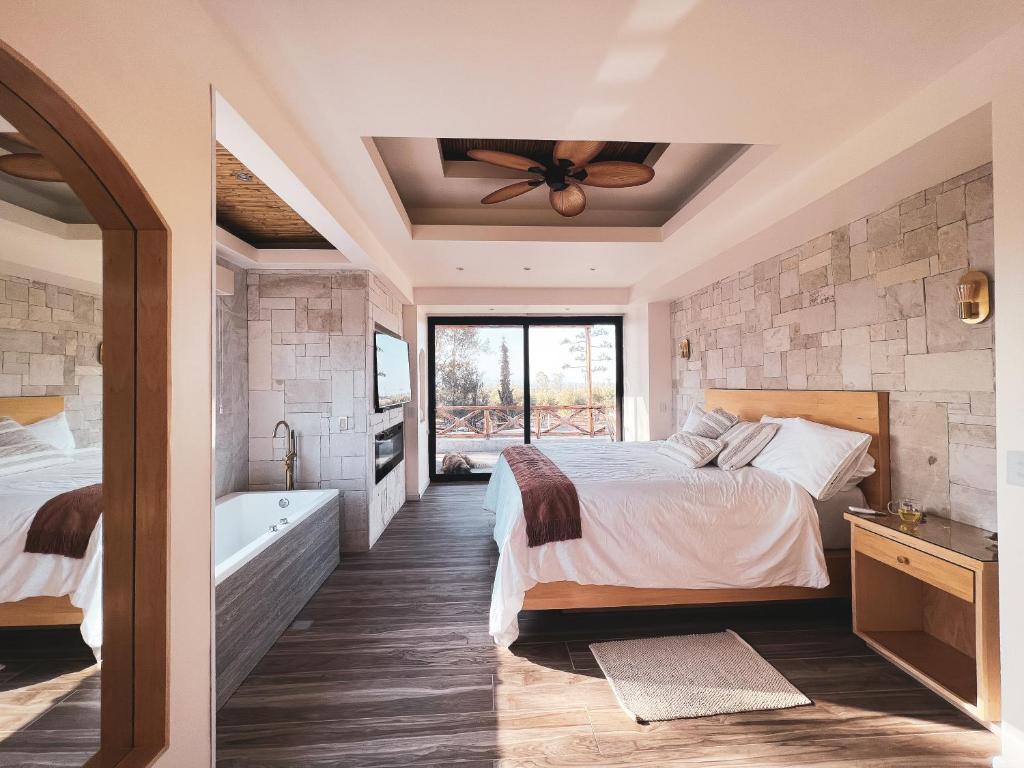 a bedroom with two beds and a bath tub at Penthouse at Hotel Boutique Valle de Guadalupe in Valle de Guadalupe