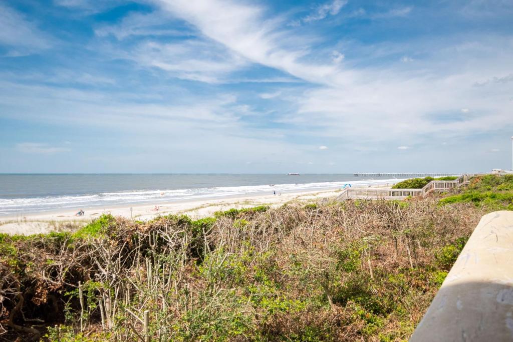 a view of a beach with people in the ocean at Beach Therapy in Caswell Beach