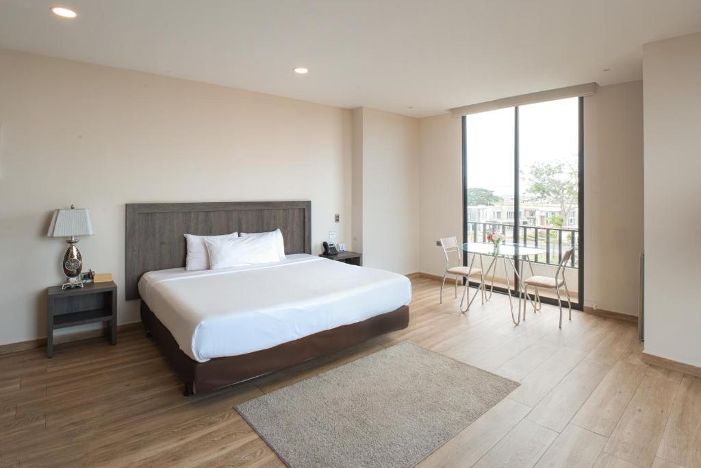 1 dormitorio con 1 cama grande y balcón en REEC Machala by Oro Verde Hotels, en Machala