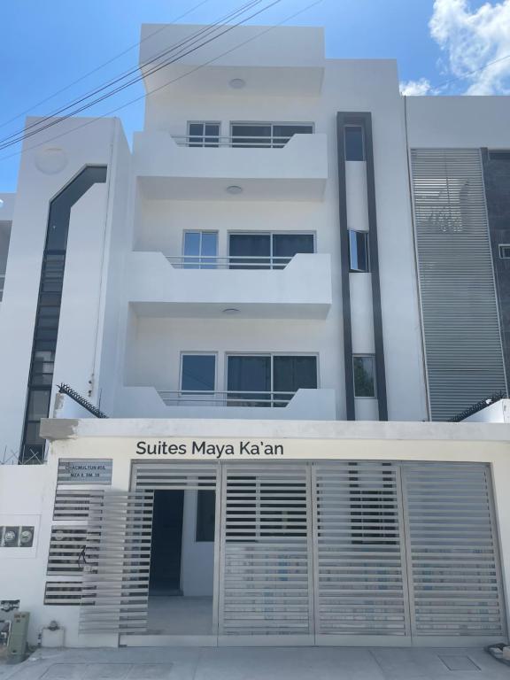 un edificio blanco con un garaje delante en Suites Maya Ka’an, en Cancún