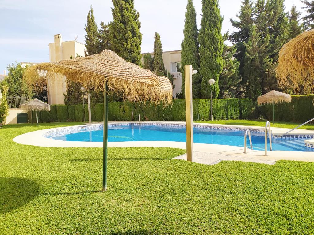 - une piscine avec un parasol dans la cour dans l'établissement INMOGEST - Apartamento Mar Golondrinas - Parking free, à Benalmádena