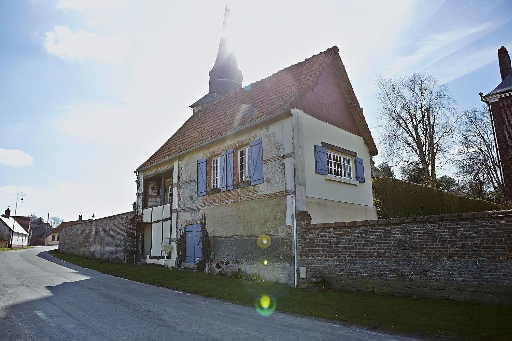 an old brick house with a turret on a street at Gîte du Presbytère de L'Abbé L'Hermina in Saint-Martin-le-Gaillard