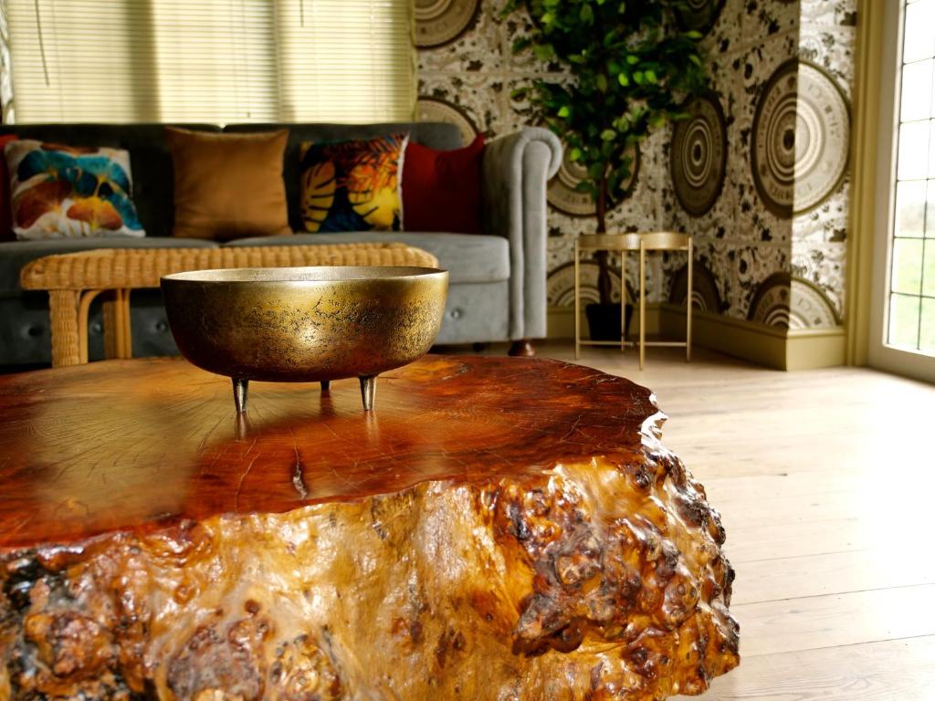 uma sala de estar com uma tigela numa mesa de madeira em Ultra Deluxe Versace Villa Hot Tub Cinema Room em Saffron Walden