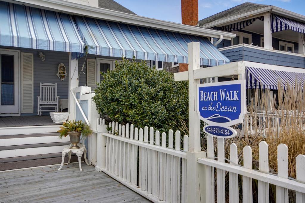 a house with a white picket fence and a back walk sign at Beach Walk on the Ocean in Ocean City