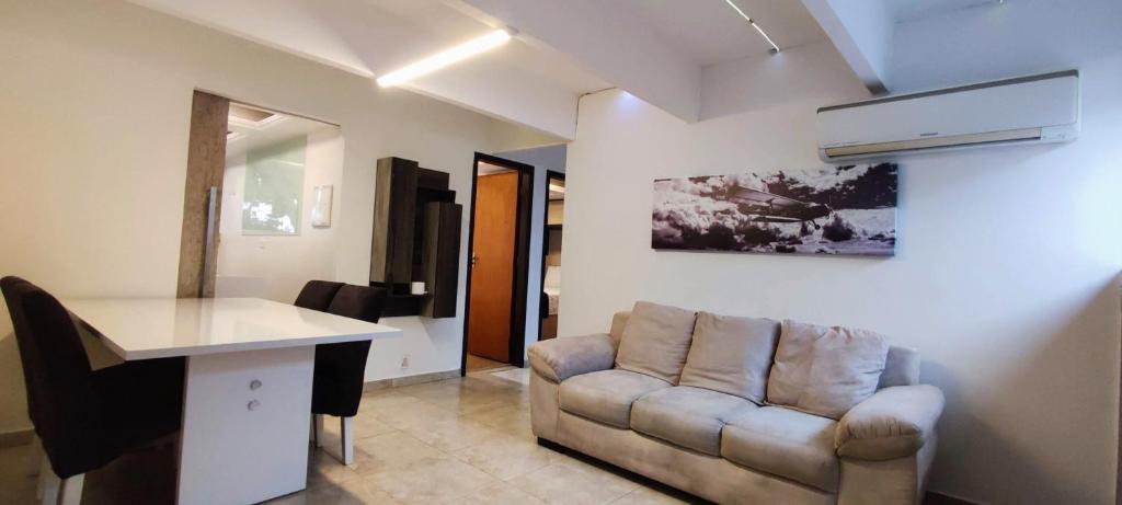 - un salon avec un canapé et une table dans l'établissement Ao Lado do Aeroporto com Ar Condicionado e vaga coberta, à Guarulhos