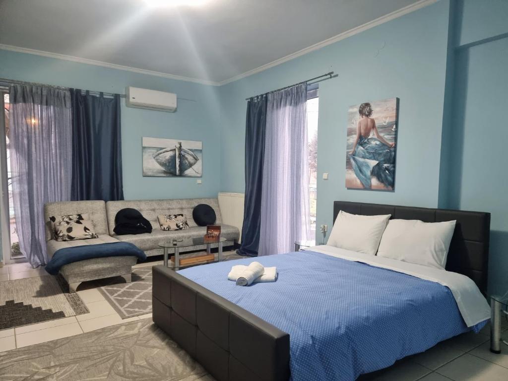 Dormitorio azul con cama y sofá en nice stay, en Tripolis