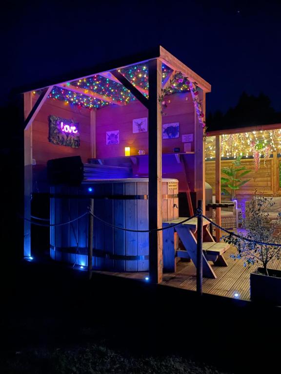 un bar en un cenador con luces de Navidad en FINN VILLAGE - Loch Lomond Sunset Glamping Pod - Private Ofuro HOT TUB en Drymen