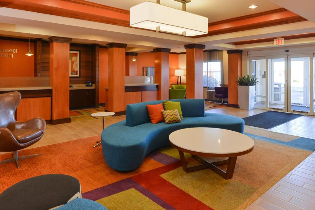 sala de estar con sofá azul y mesa en Fairfield Inn & Suites Bloomington, en Bloomington