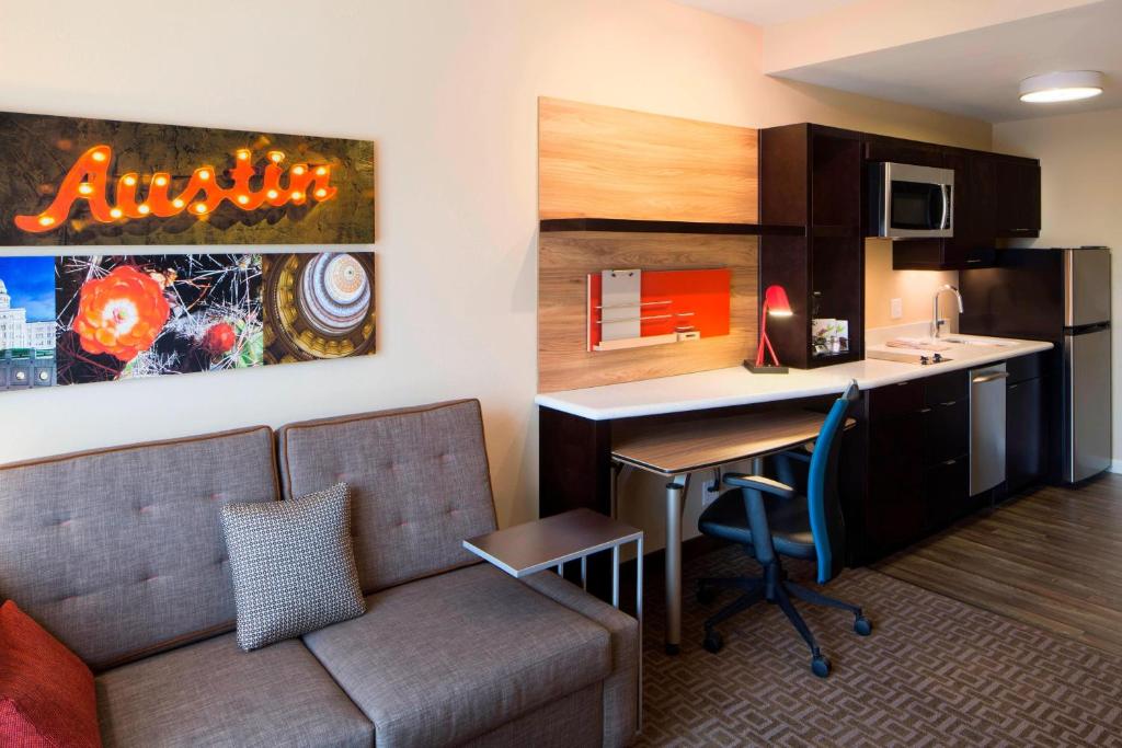 a living room with a couch and a desk in a room at TownePlace Suites by Marriott Austin Round Rock in Round Rock