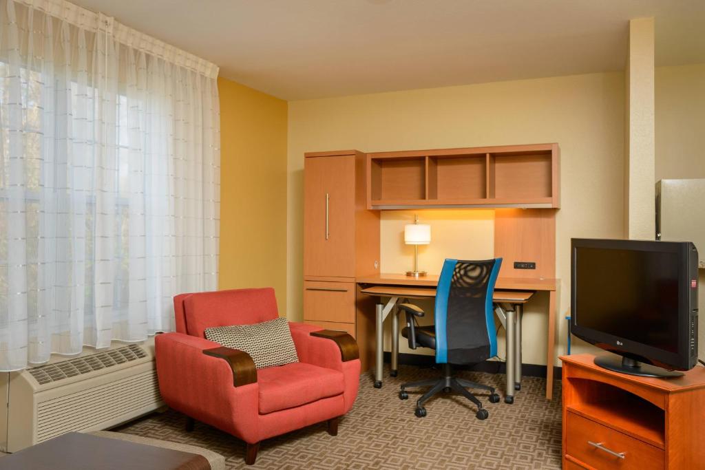 um quarto com uma secretária, uma cadeira e uma televisão em TownePlace Suites by Marriott Fort Meade National Business Park em Annapolis Junction