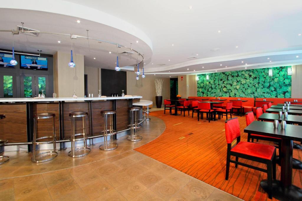 un restaurant avec un bar, des tables et des chaises dans l'établissement Courtyard by Marriott Lyndhurst/Meadowlands, à Lyndhurst