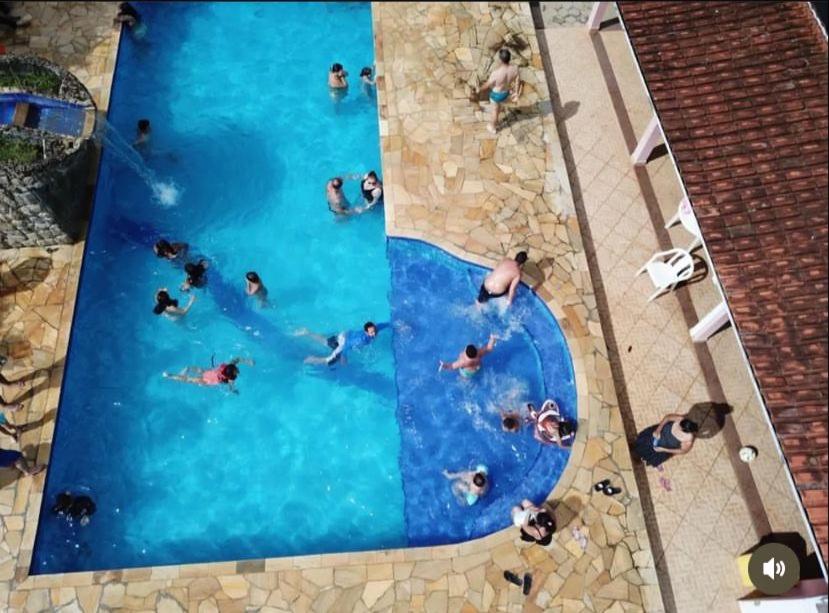 un grupo de personas nadando en una piscina en Pousada camping Recanto Joanópolis en Joanópolis