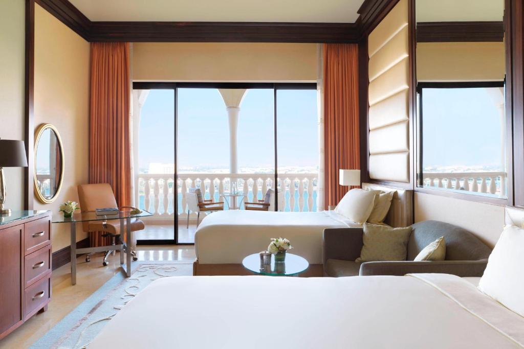 a hotel room with two beds and a balcony at The Ritz-Carlton Abu Dhabi, Grand Canal in Abu Dhabi