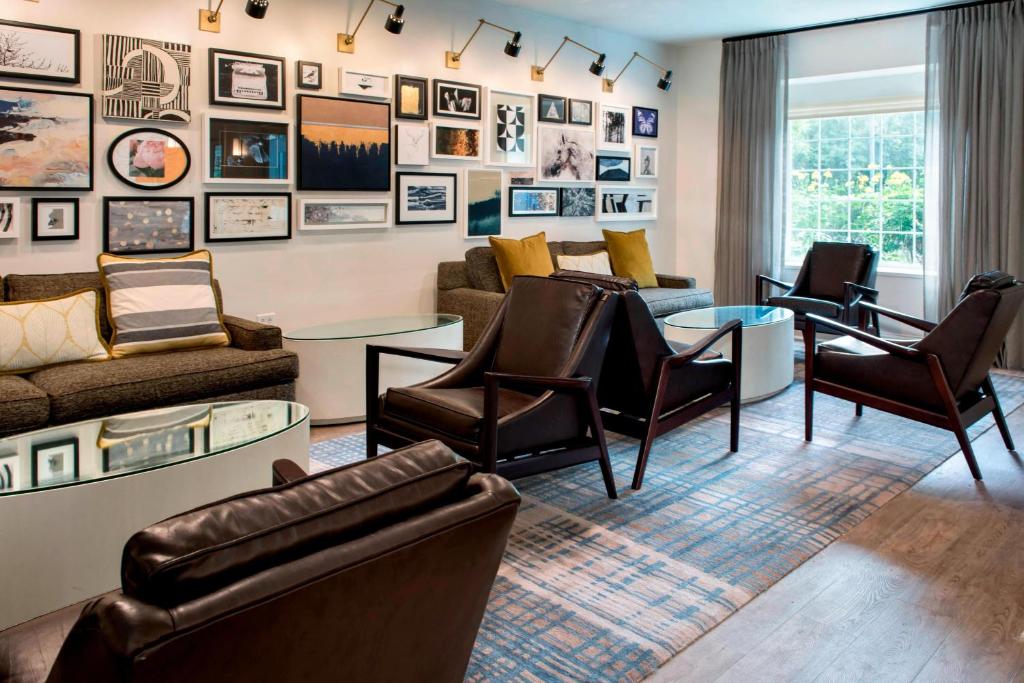 a living room with leather furniture and pictures on the wall at Delta Hotels by Marriott Basking Ridge in Basking Ridge