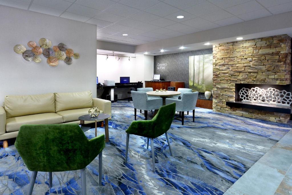 vestíbulo con sofá, sillas y chimenea en Fairfield Inn & Suites by Marriott Charlottesville North, en Charlottesville