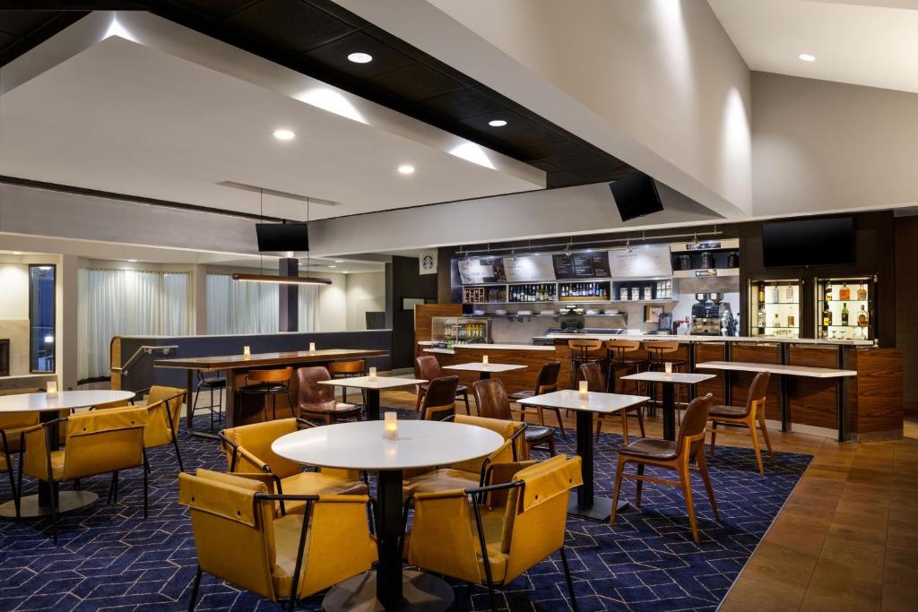 a restaurant with tables and chairs and a bar at Courtyard by Marriott Denver Central Park in Denver