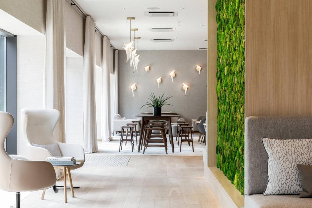 uma sala de jantar com uma parede verde em AC Hotel by Marriott Berlin Humboldthain Park em Berlim