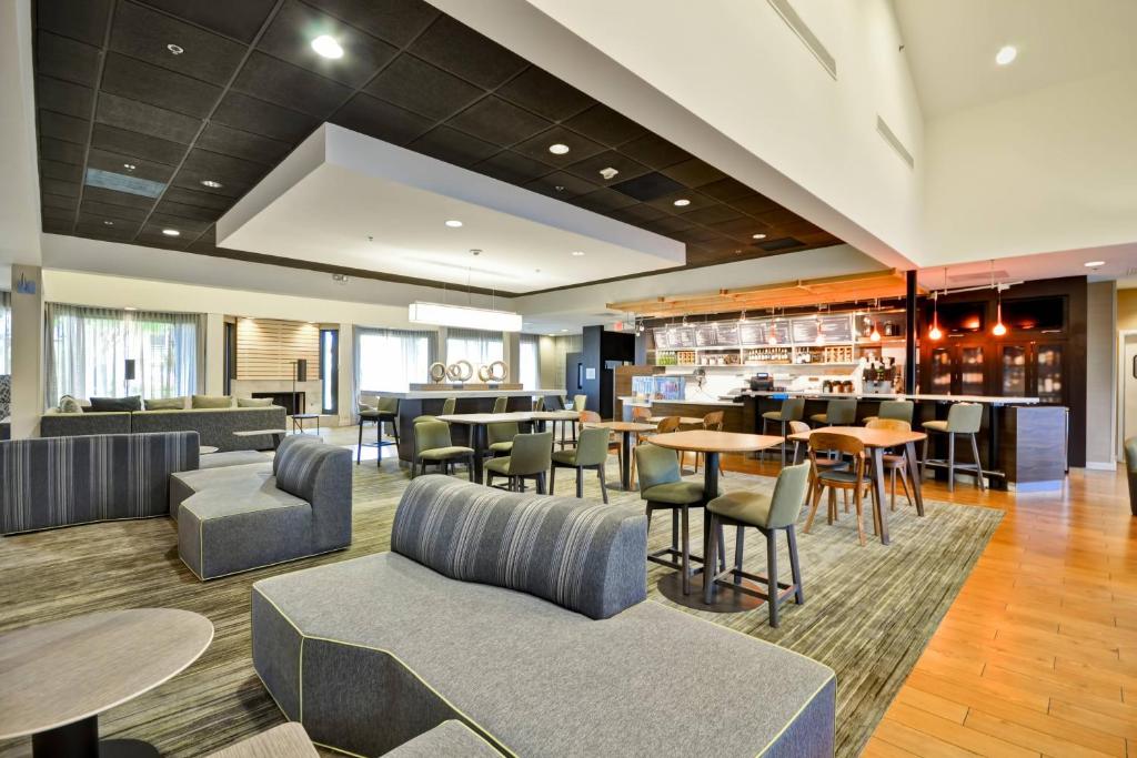 a hotel lobby with tables and chairs and a bar at Courtyard Dallas Medical Market Center in Dallas