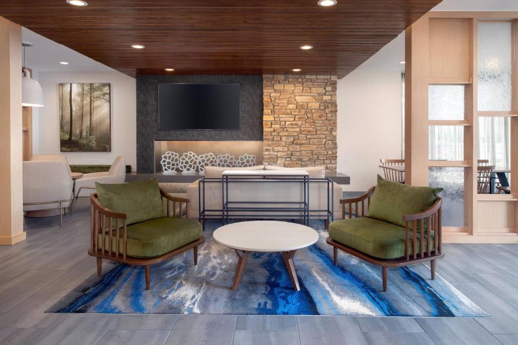 a lobby with chairs and a table and a tv at Fairfield by Marriott Inn & Suites Aberdeen in Aberdeen