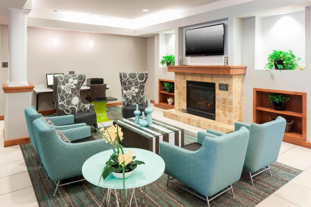 sala de estar con sillas azules y chimenea en Residence Inn by Marriott Chicago Lake Forest/Mettawa, en Mettawa