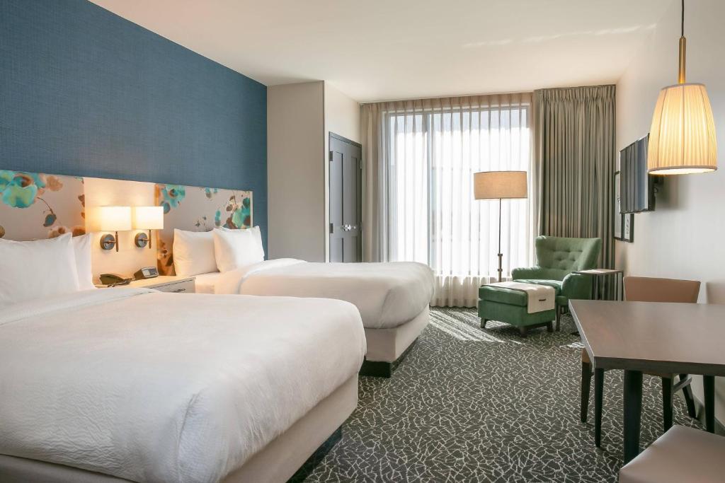 um quarto de hotel com duas camas e uma cadeira em TownePlace Suites Nashville Downtown/Capitol District em Nashville