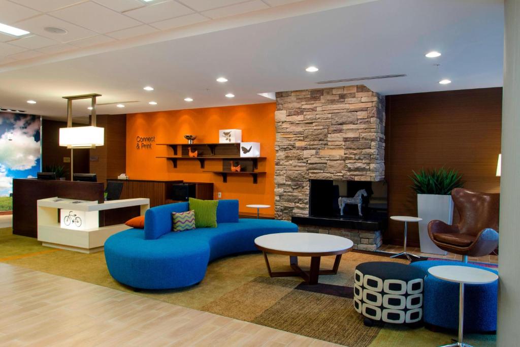 a living room with a blue couch and a fireplace at Fairfield Inn & Suites by Marriott Atlanta Cumming/Johns Creek in Cumming