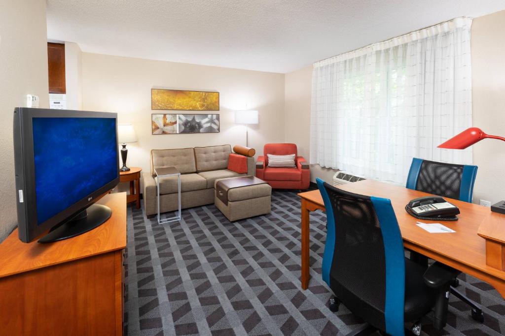 a living room with a desk and a tv in a room at TownePlace Suites Bowie Town Center in Bowie