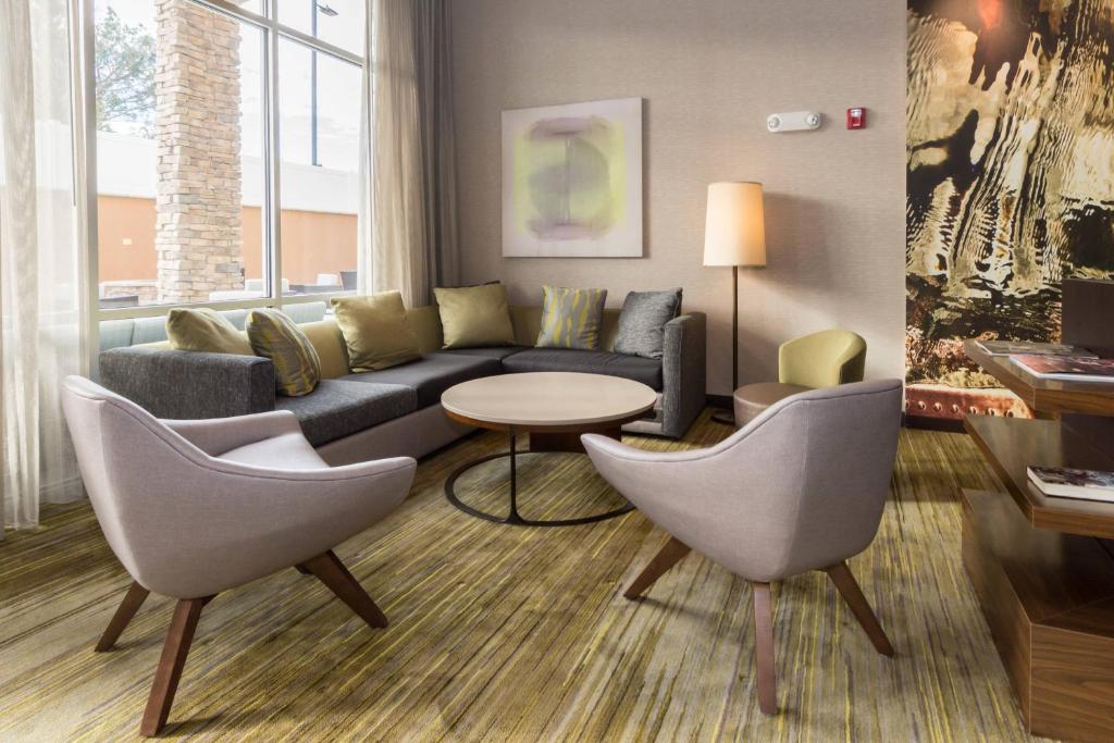 a living room with a couch and chairs and a table at Courtyard by Marriott Fayetteville Fort Bragg/Spring Lake in Spring Lake