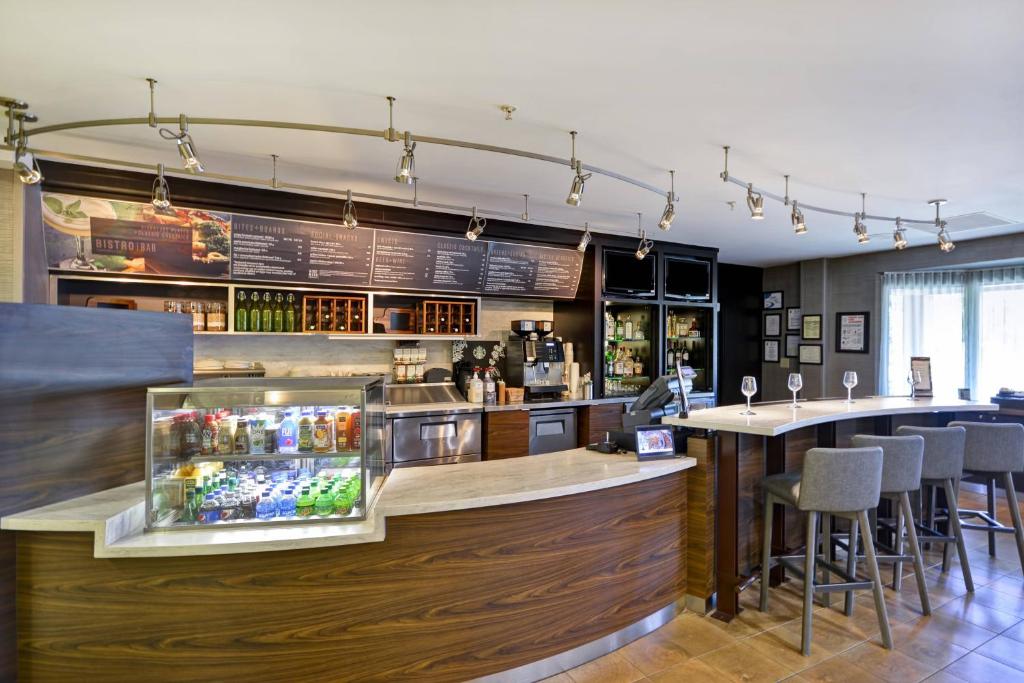 a bar in a restaurant with a counter with stools at Courtyard by Marriott Dalton in Dalton