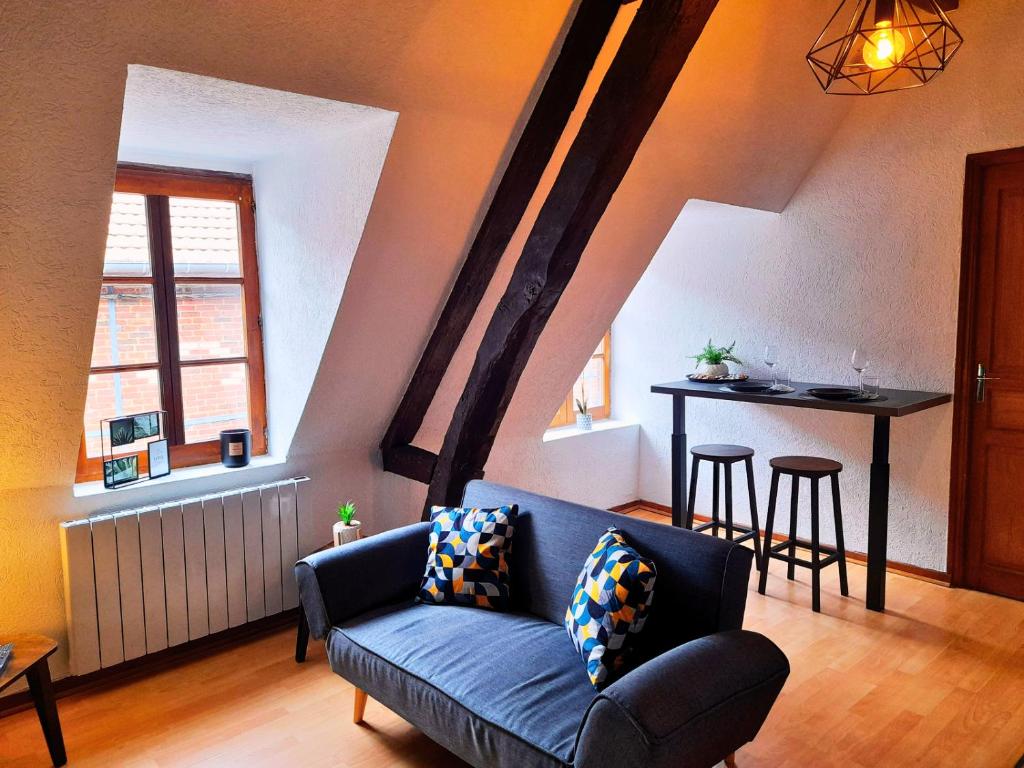 - un salon avec un canapé bleu et une table dans l'établissement L'Authentique - Hyper Centre, à Beauvais