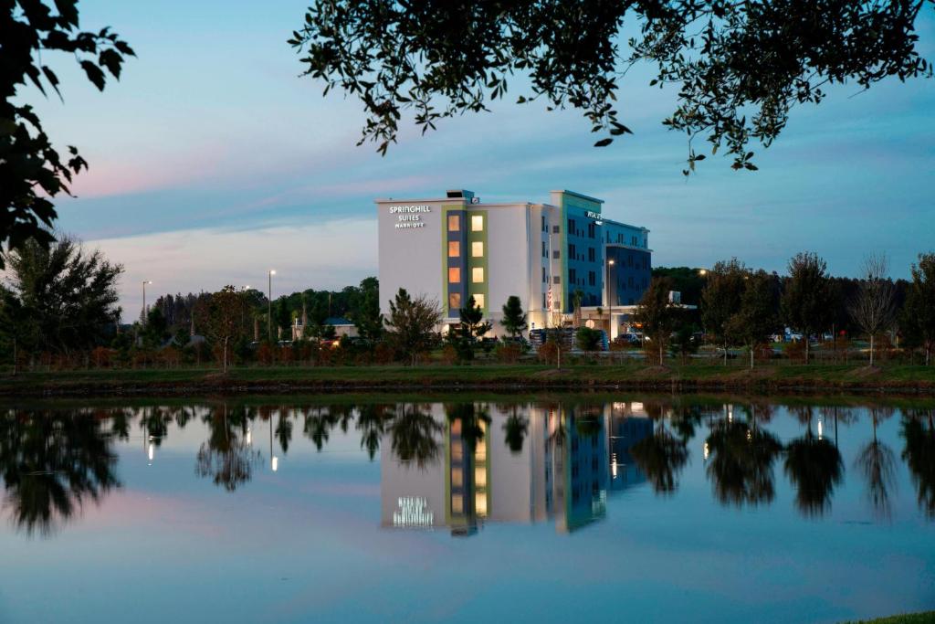 een gebouw met zijn reflectie in het water bij SpringHill Suites by Marriott Tampa Suncoast Parkway in Land O' Lakes