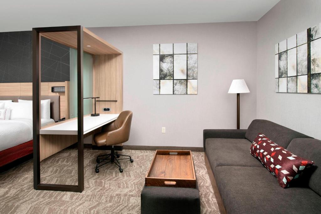 a living room with a couch and a desk in a hotel room at SpringHill Suites by Marriott Albuquerque North/Journal Center in Alameda