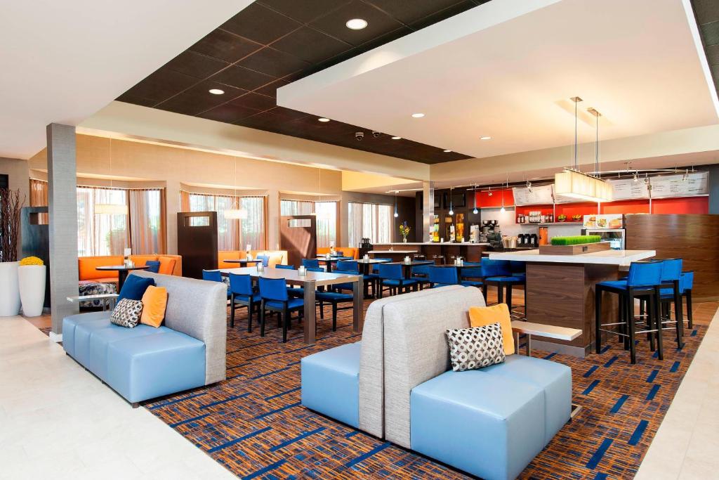 a restaurant with blue chairs and tables and a bar at Courtyard Chicago Glenview/Northbrook in Glenview