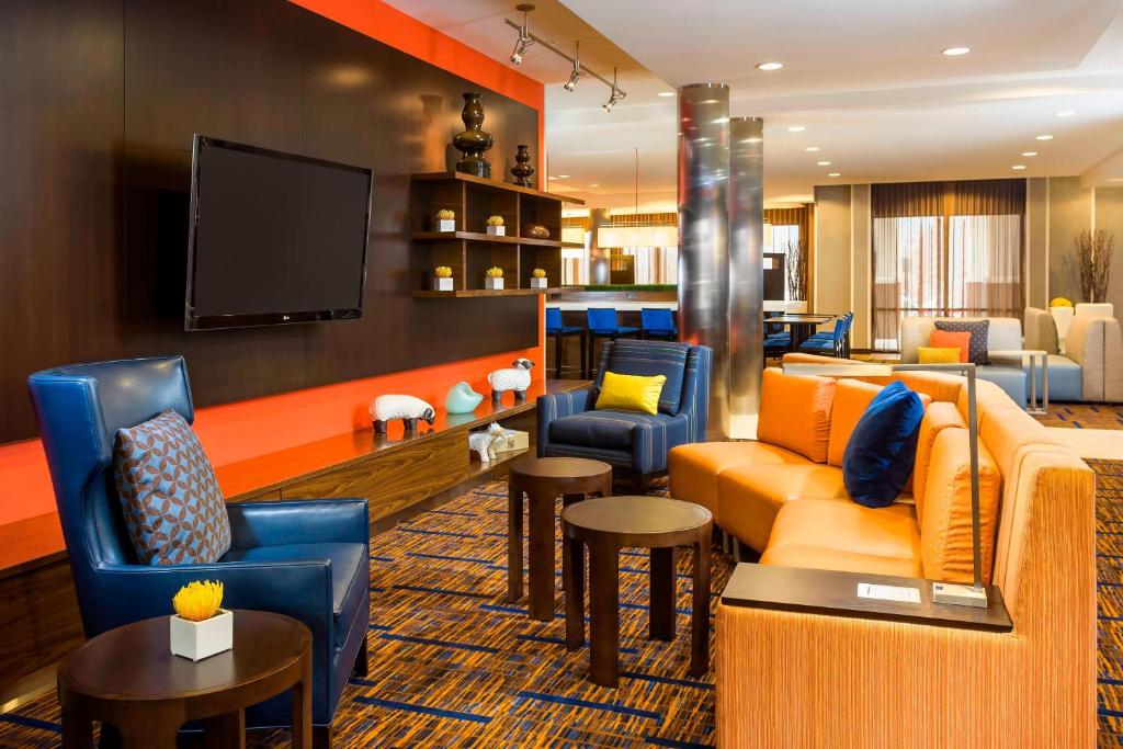 uma sala de estar com sofás e uma televisão de ecrã plano em Courtyard by Marriott Stafford Quantico em Triangle