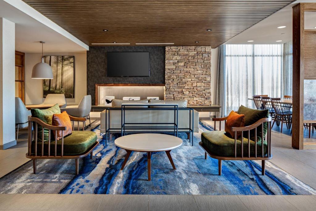 a hotel lobby with chairs and a table at Fairfield Inn & Suites by Marriott Fayetteville in Fayetteville