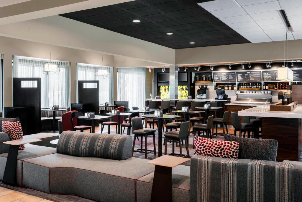a restaurant with tables and chairs and a bar at Courtyard Chicago O'Hare in Des Plaines