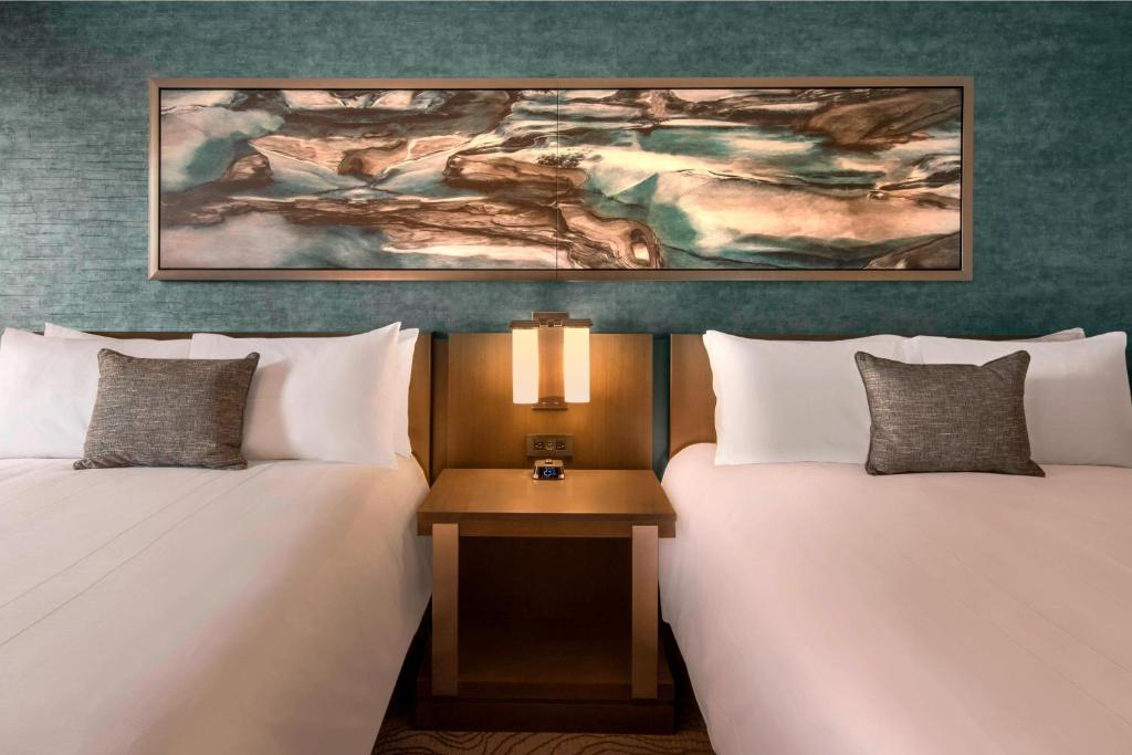 2 Betten in einem Hotelzimmer mit Wandgemälde in der Unterkunft Denver Marriott Tech Center in Greenwood Village