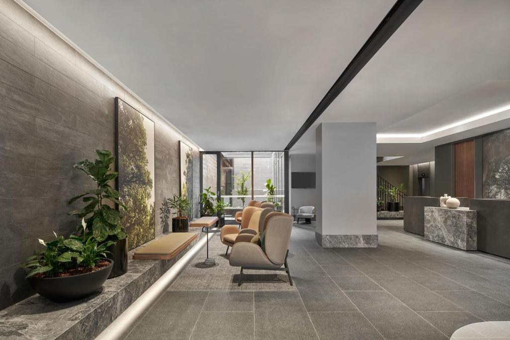 an office lobby with chairs and plants at Courtyard by Marriott Melbourne Flagstaff Gardens in Melbourne