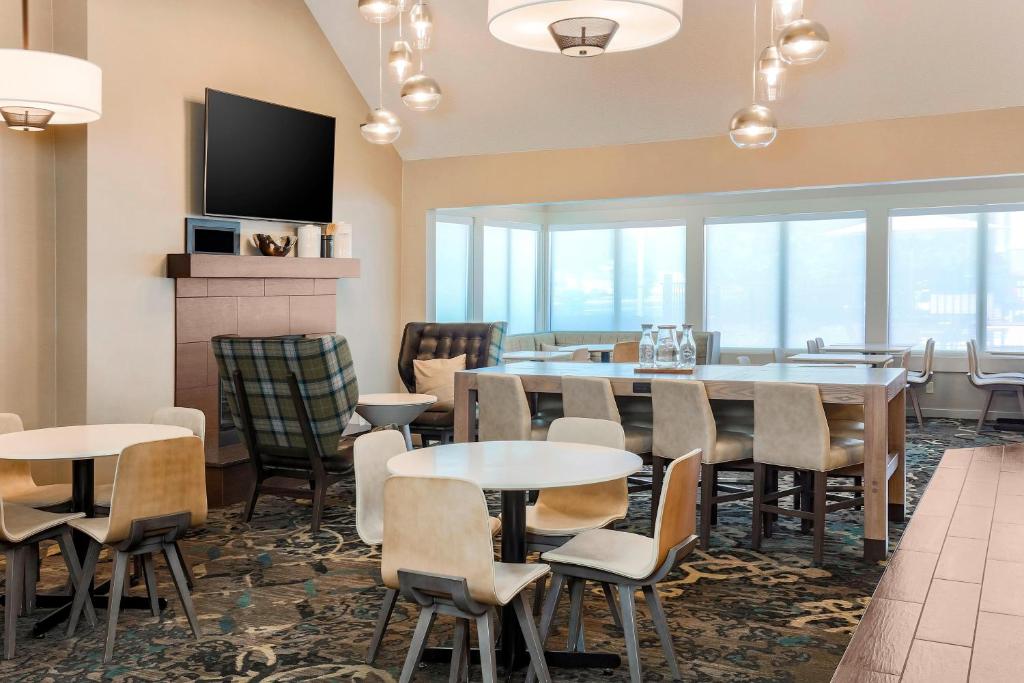 a restaurant with tables and chairs and a tv at Residence Inn Chicago Deerfield in Deerfield